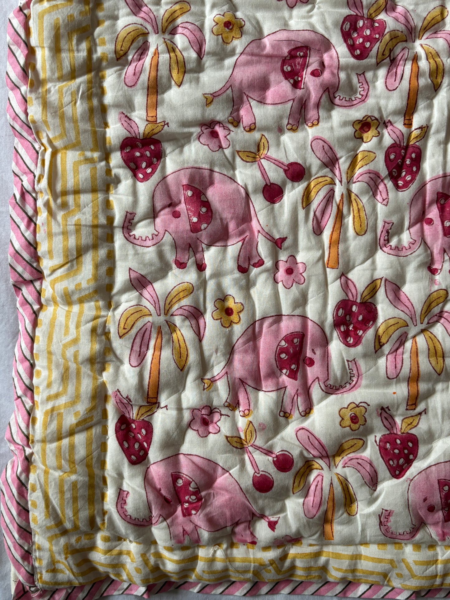 Quilt with pink elephants and floral patterns 