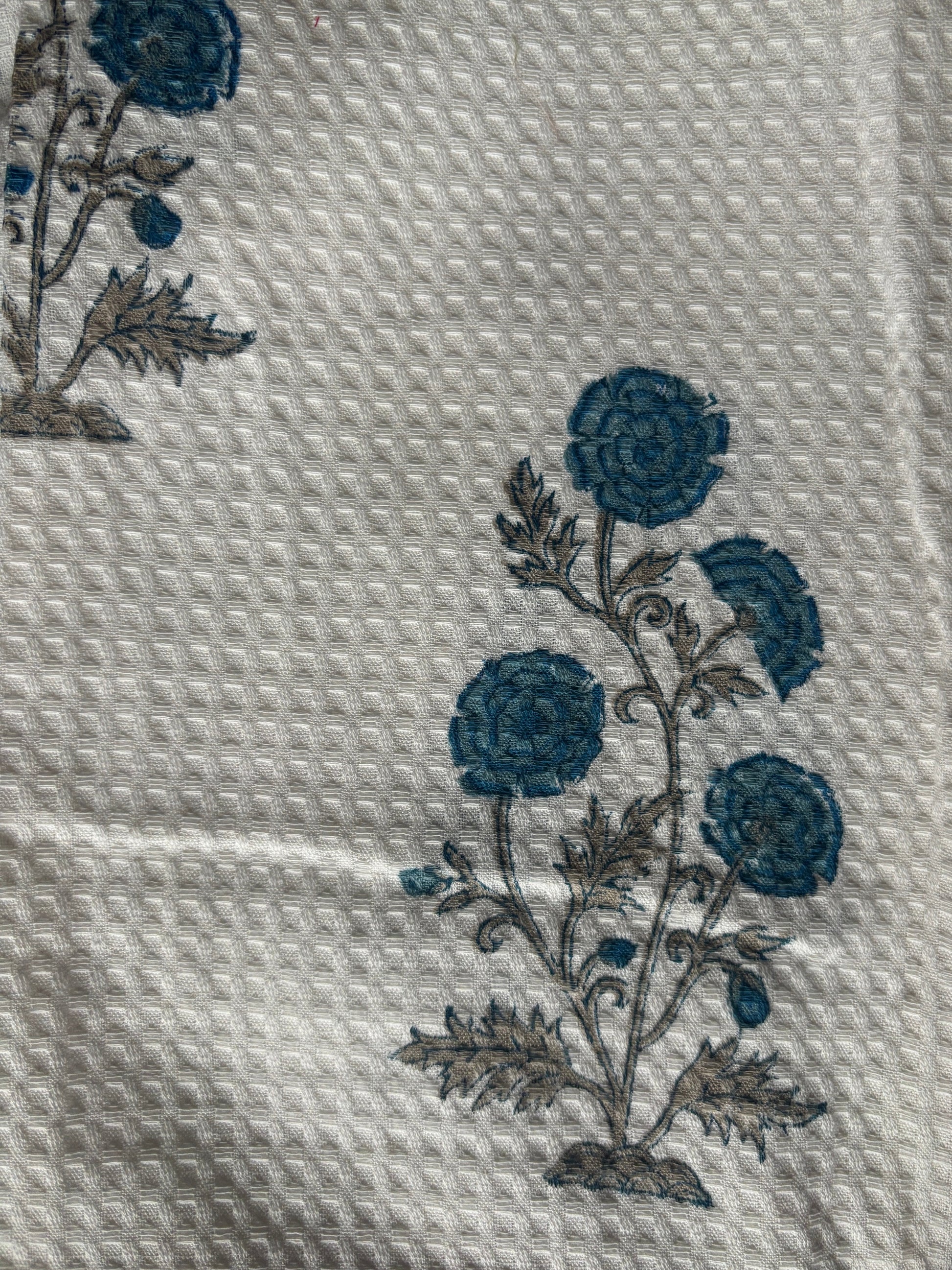 White textured fabric with blue floral block print motif