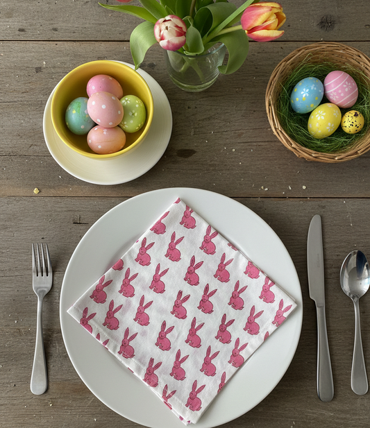 Easter table setting with a plate, napkin, and Easter eggs on a wooden table.