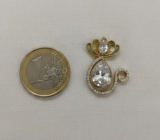 Gold earring next to a €1 coin on a light gray background