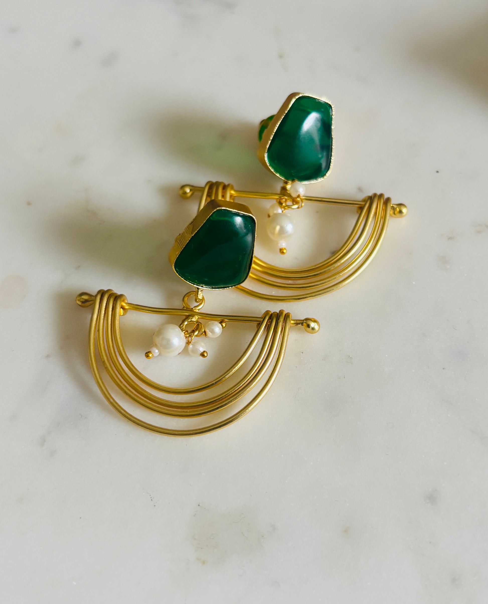 Emerald arc pearl drop earrings featuring deep green stones and pearl detail in an elegant drop design, handcrafted jewellery.