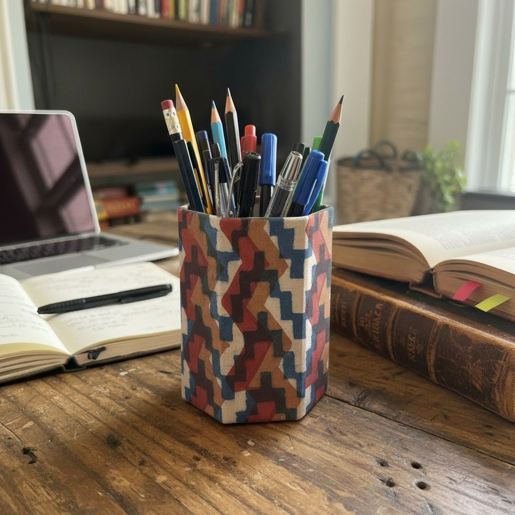 Block Printing Patterned pencil holder with pens on a desk with books and a laptop.